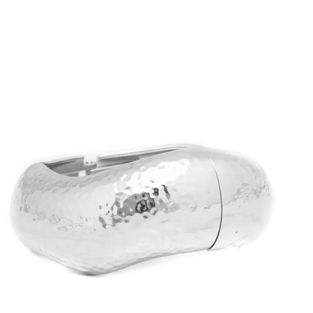 Hand-hammered silver wave bangle bracelet by Vault No.9. A sculptural, volumetric statement piece designed for modern permanence.