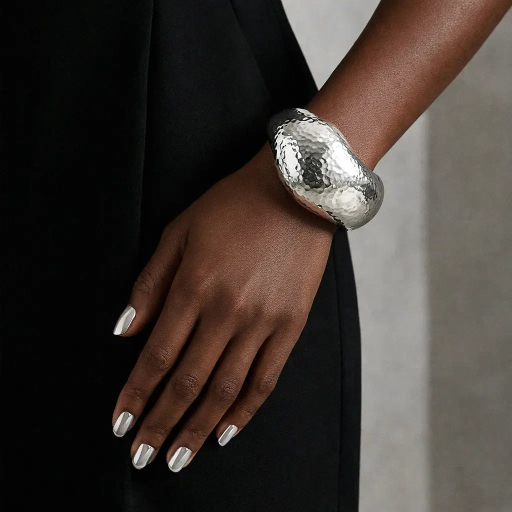 Hand-hammered silver wave bangle bracelet by Vault No.9. A sculptural, volumetric statement piece designed for modern permanence.
