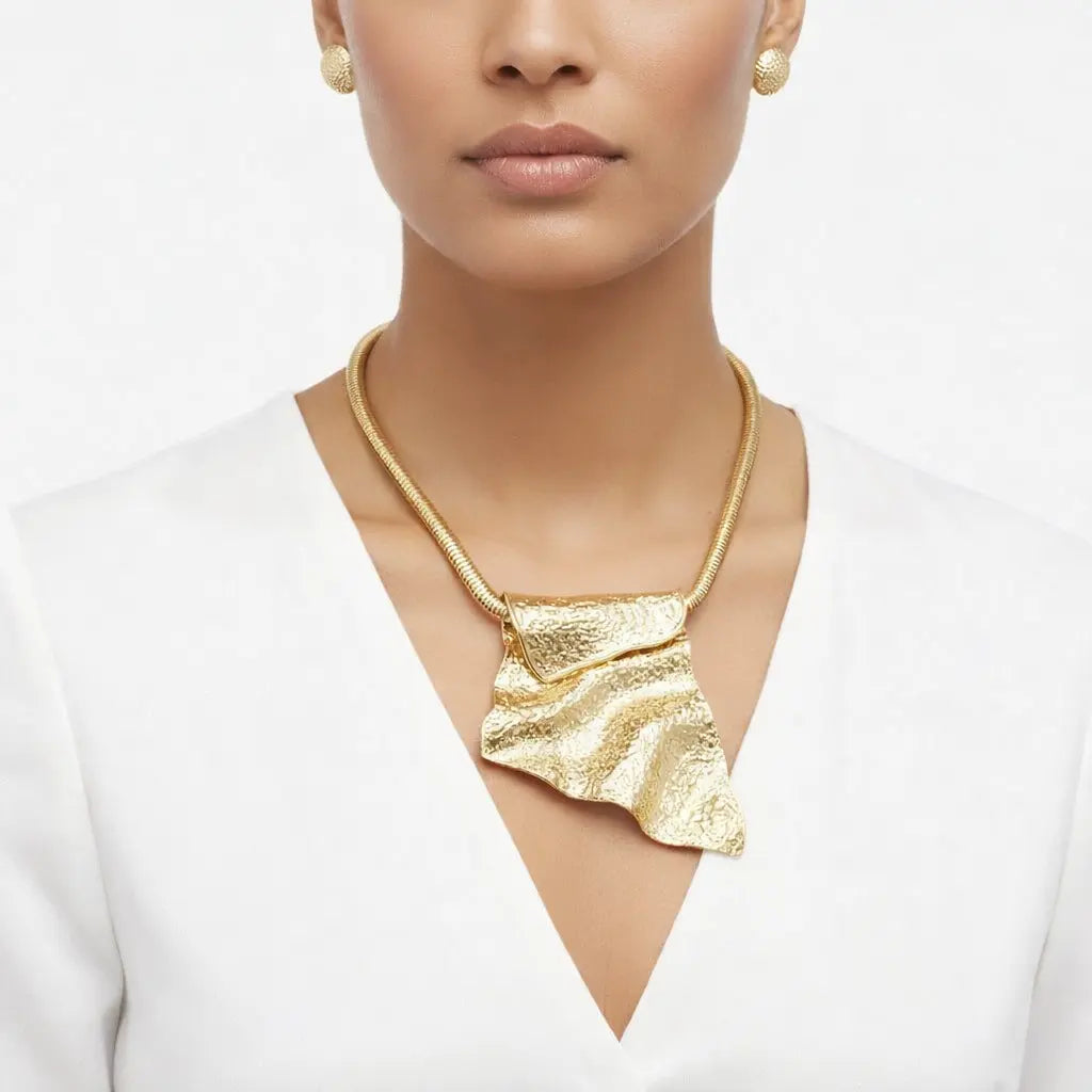 Architectural silver pendant necklace with a sculptural folded metal design. Intentional jewelry crafted to anchor a woman's wardrobe.